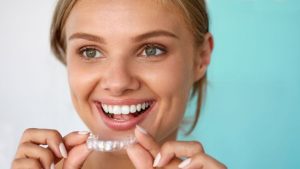 Smiling Woman With Invisalign In Her Hand